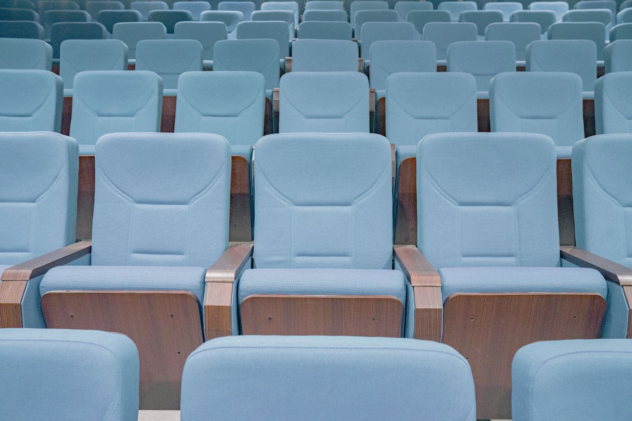 Rows of modern blue theater seats in an empty auditorium, highlighting architectural design.